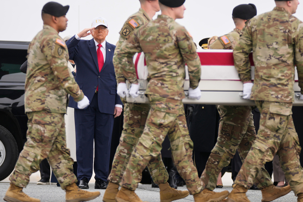 An Army carry team moves a flag-draped transfer case with the remains of U.S. Army Reserve soldier Sgt. 1st Class Nicole Amor, of White Bear Lake, Minn., who was killed in a drone strike at a command center in Kuwait after the U.S. and Israel launched its military campaign against Iran, past President Donald Trump during a casualty return, Saturday, March 7, 2026, at Dover Air Force Base, Del. (AP Photo/Mark Schiefelbein)
