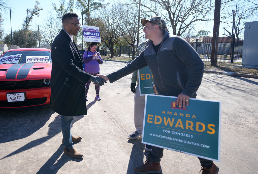 Texas Congressional Candidate Christian D. Menefee shakes hands with Patrick Edge, a poll worker for Amanda Edwards, as he visited a polling location at Acres Homes MultiService Center on Election Day, in Houston, Saturday, Jan. 31, 2026. (AP Photo/ Karen Warren)