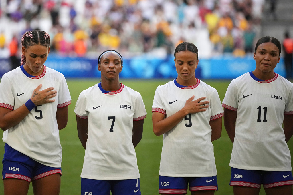 FILE - From left; United States' Trinity Rodman, Crystal Dunn, Mallory Swanson and Sophia Smith listen to the national anthem ahead of a women's Group B soccer match between Australia and the United States, at the Marseille Stadium during the 2024 Summer Olympics, in Marseille, France, July 31, 2024,. (AP Photo/Daniel Cole, File)