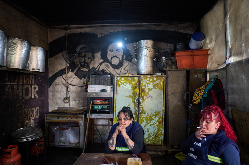 Union of Workers of the Popular Economy volunteers Valeria Espindola, center, and Rosana Barberis rest after serving free meals in Buenos Aires, Argentina, Wednesday, Sept. 23, 2026. (AP Photo/Rodrigo Abd)