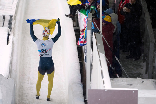 FILE - Valdyslav Heraskevych, of Ukraine, waves a flag as he finishes his second run during the World Cup skeleton competition in Lake Placid, N.Y., March 21, 2024. (AP Photo/Seth Wenig) FILE - Valdyslav Heraskevych, of Ukraine, waves a flag as he finishes his second run during the World Cup skeleton competition in Lake Placid, N.Y., March 21, 2024. (AP Photo/Seth Wenig)