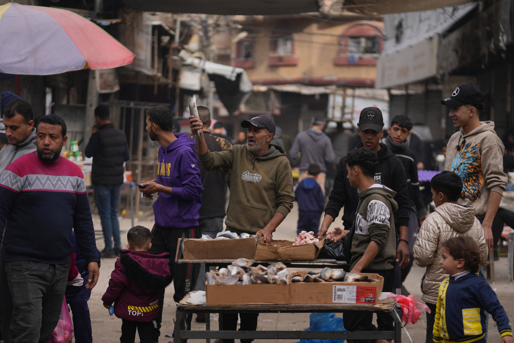 A Palestinian vendor displays sardines for sale on a street of a local market in Gaza City, Friday, Dec. 19, 2025. (AP Photo/Abdel Kareem Hana)