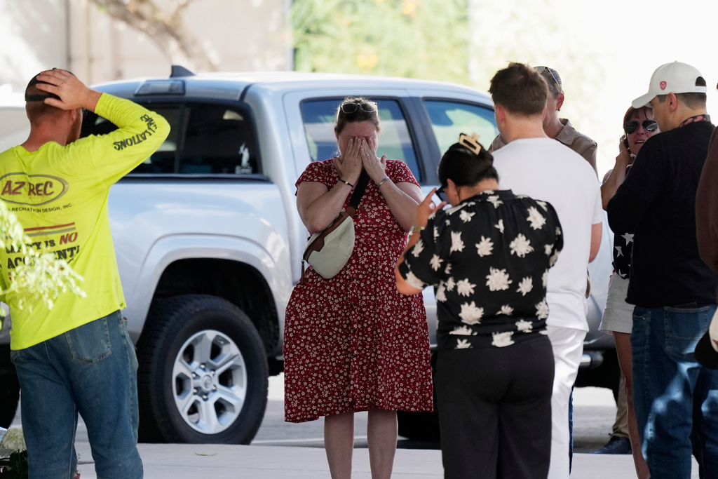 Well-wishers pray at the national headquarters of Turning Point USA shown after the shooting death of Charlie Kirk, the co-founder and CEO of the organization, during a Utah college event, Wednesday, Sept. 10, 2025, in Phoenix. (AP Photo/Ross D. Franklin)