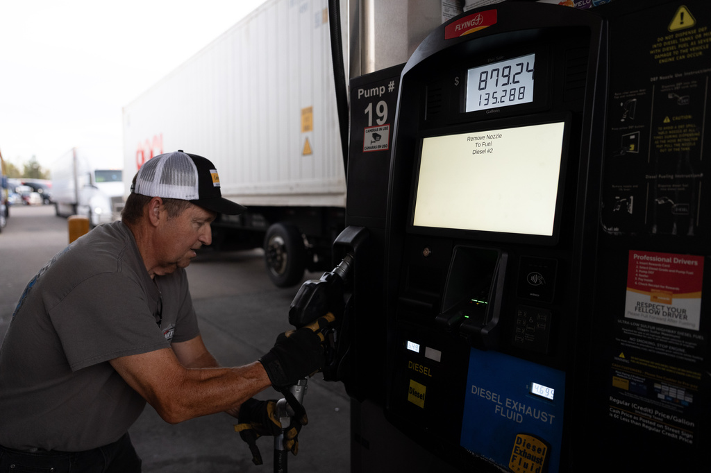 Chuck Byrd puts away a fuel nozzel after filling two tanks for a truck at a gas station on Tuesday, April 7, 2026, in Aurora, Ore. (AP Photo/Jenny Kane)