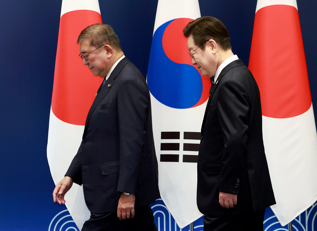 South Korean President Lee Jae Myung, right, walks with Japanese Prime Minister Shigeru Ishiba on their way to hold a meeting in Busan, South Korea, Tuesday, Sept. 30, 2025. (Yonhap via AP)