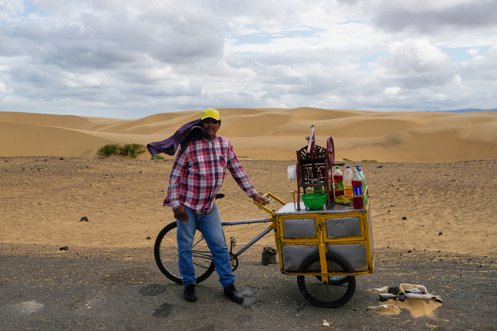 Jarrison Arias sells shaved-ice treats along the road at Medanos de Coro National Park in Venezuela, Wednesday, Jan. 14, 2026. (AP Photo/Matias Delacroix)