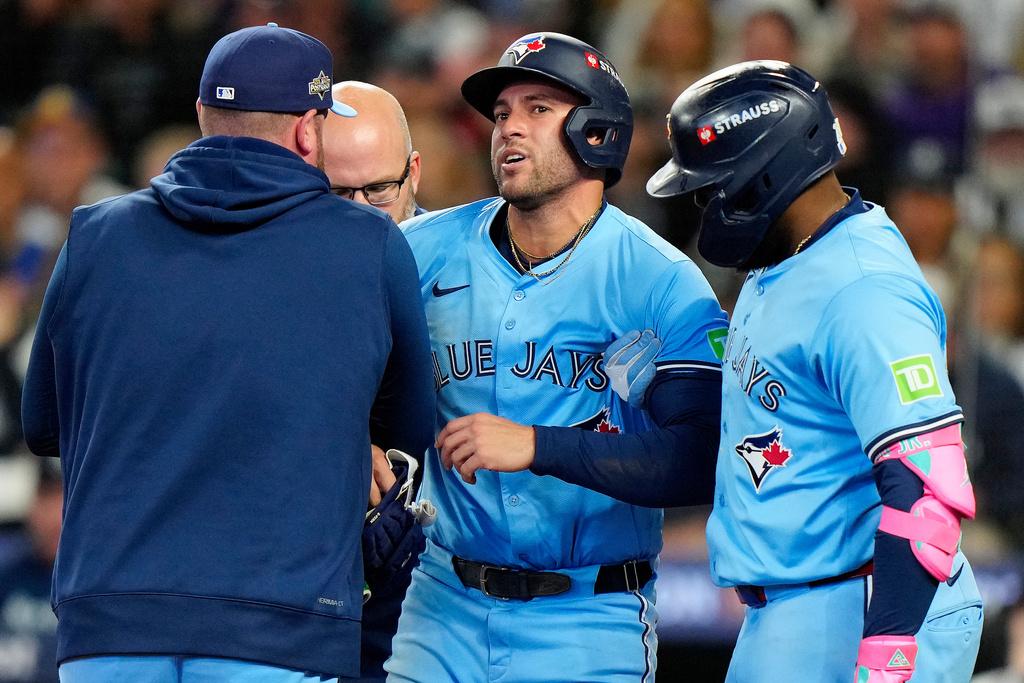Teammates and staff help Toronto Blue Jays outfielder George Springer (4) off the field after he took a pitch to the knee from Seattle Mariners pitcher Bryan Woo (22) during seventh inning MLB Game 5 of baseball's American League Championship Series action in Seattle, Friday, Oct. 17, 2025. (Frank Gunn/The Canadian Press via AP)