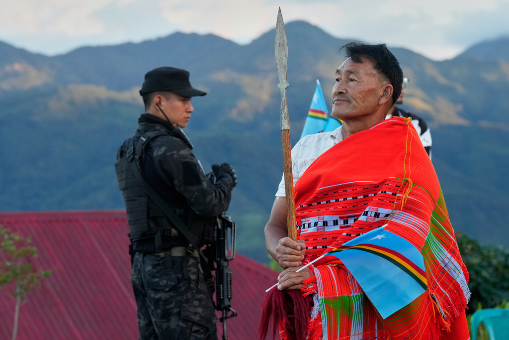A Naga wearing traditional attire stands next to an armed cadre of the National Socialist Council of Nagaland (Isak-Muivah) in Somdal village, in the northeastern Indian state of Manipur, Wednesday, Oct. 22, 2025. (AP Photo/Anupam Nath)