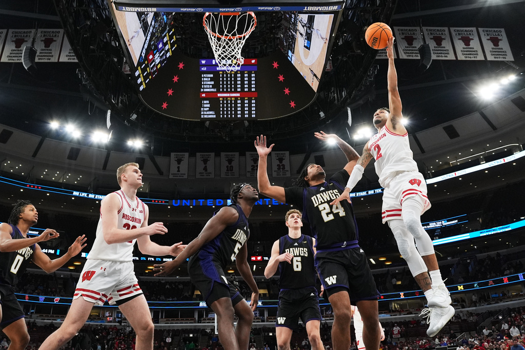 Wisconsin guard Nick Boyd, right, drives to the basket against Washington center Lathan Sommerville (24) during the first half of an NCAA college basketball game in the third round of the Big 10 Conference tournament Thursday, March 12, 2026, in Chicago. (AP Photo/Nam Y. Huh)
