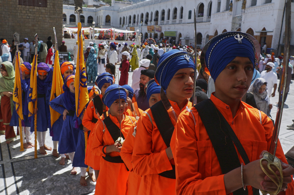 Sikh youth, in traditional dress and holding ceremonial swords, attend a ceremony to celebrate Vaisakhi festival, which also marks the New Year in Sikh tradition, at the shrine of Gurdwara Punja Sahib, the second most sacred place for Sikhs, in Hassan Abdal, Pakistan, Tuesday, April 14, 2026. (AP Photo/Anjum Naveed)