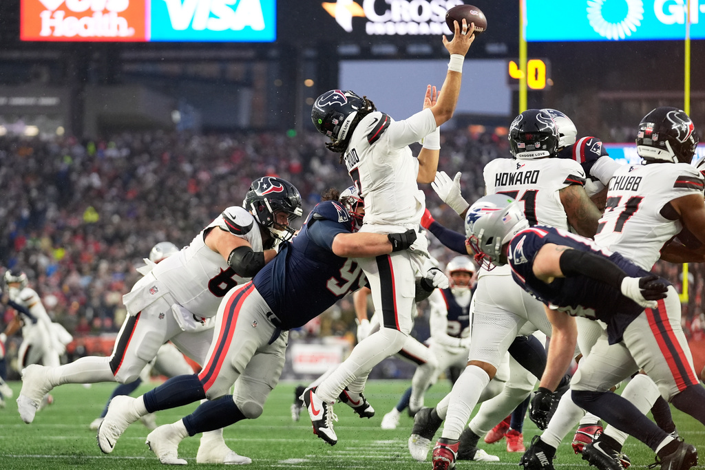 Houston Texans quarterback C.J. Stroud, middle, is hit by New England Patriots defensive tackle Khyiris Tonga while throwing an incomplete pass during the first half of an NFL divisional playoff football game, Sunday, Jan. 18, 2026, in Foxborough, Mass. (AP Photo/Robert F. Bukaty)
