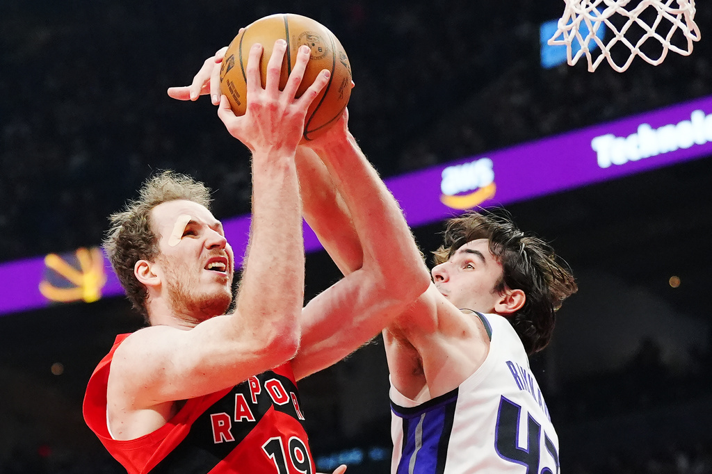 Toronto Raptors' Jakob Poeltl (left) is fouled by Sacramento Kings' Maxime Raynaud (42) during the first half of an NBA basketball game in Toronto, Wednesday, April 1, 2026. (Frank Gunn/The Canadian Press via AP)