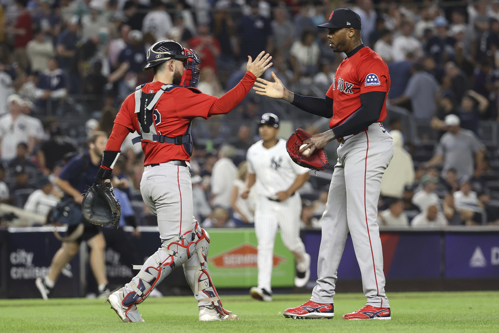 Boston Red Sox catcher Connor Wong, left, and pitcher Aroldis Chapman, right, react after defeating the New York Yankees during a baseball game Friday, Aug. 22, 2025, in New York. (AP Photo/Pamela Smith)