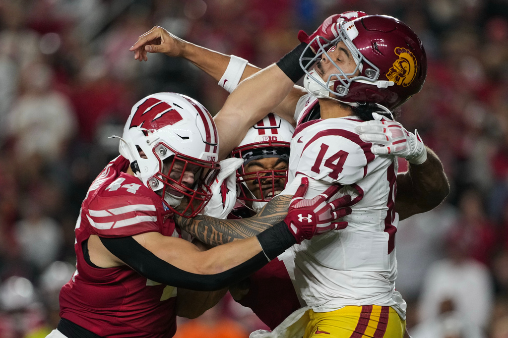 Southern California quarterback Jayden Maiava (14) is pressured by Wisconsin linebacker Cooper Catalano (44) and Wisconsin linebacker Sebastian Cheeks, center, during an NCAA college football game Saturday, Oct. 24, 2026, in Madison, Wis. (AP Photo/Ross Harried)