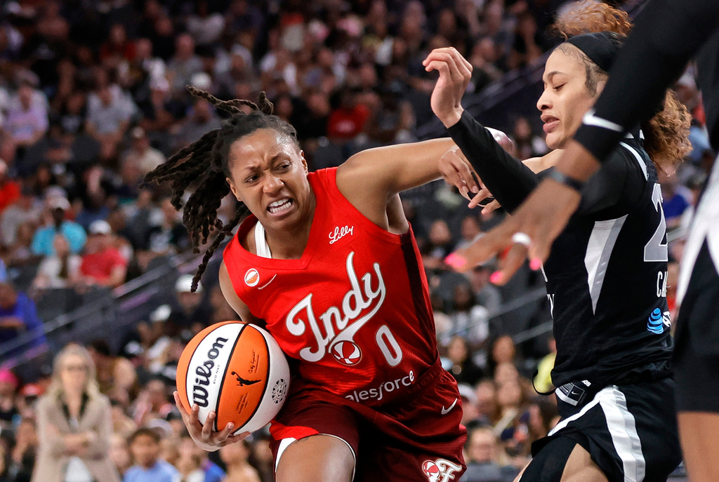 Indiana Fever guard Kelsey Mitchell (0) drives against Las Vegas Aces guard Chennedy Carter (23) during the first half of an WNBA basketball game Sunday, July 5, 2026, in Las Vegas. (Steve Marcus/Las Vegas Sun via AP)