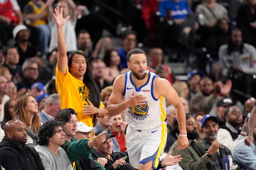 A Golden State Warriors fan celebrates after Warriors guard Stephen Curry, right, scored during the second half of an NBA play-in tournament basketball game against the Los Angeles Clippers, Wednesday, April 15, 2026, in Inglewood, Calif. (AP Photo/Mark J. Terrill)