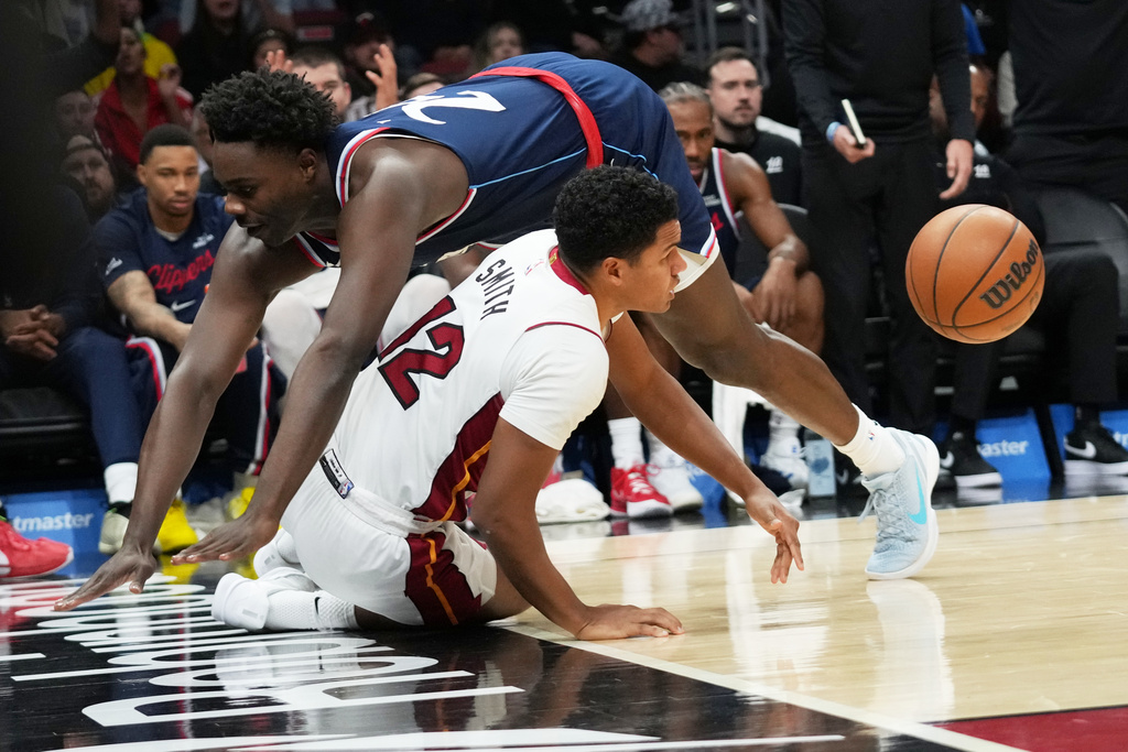 Miami Heat guard Dru Smith (12) is fouled by Los Angeles Clippers guard Kobe Brown during the first half of an NBA basketball game, Monday, Dec. 1, 2025, in Miami. (AP Photo/Lynne Sladky)