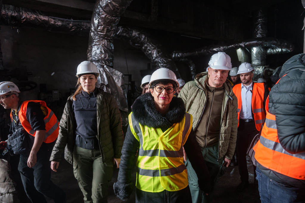 EU Commissioner for Enlargement Marta Kos, front, looks at a production hall damaged after a recent Russian missile attack at DTEK's power plant in Ukraine, on Wednesday, Dec. 10, 2025. (AP Photo/Evgeniy Maloletka)