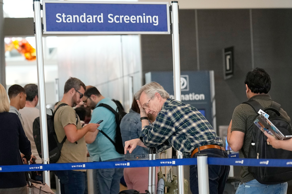 Travelers wait in long security checkpoint lines at George Bush Intercontinental Airport Friday, March 27, 2026, in Houston. (AP Photo/David J. Phillip)
