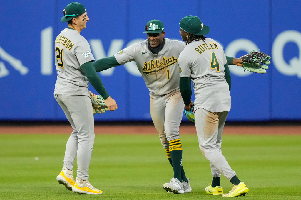Athletics right fielder Lawrence Butler (4), Athletics center fielder Denzel Clarke (1) and Athletics left fielder Tyler Soderstrom (21) celebrate after winning a baseball game against the New York Mets, Saturday, April 11, 2026, in New York. (AP Photo/Yuki Iwamura)
