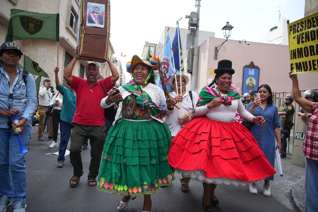Demonstrators celebrate after Congress voted to remove interim President Jose Jeri as he faces corruption allegations outside the site where lawmakers met in Lima, Peru, Tuesday, Feb. 17, 2026. (AP Photo/Guadalupe Pardo)