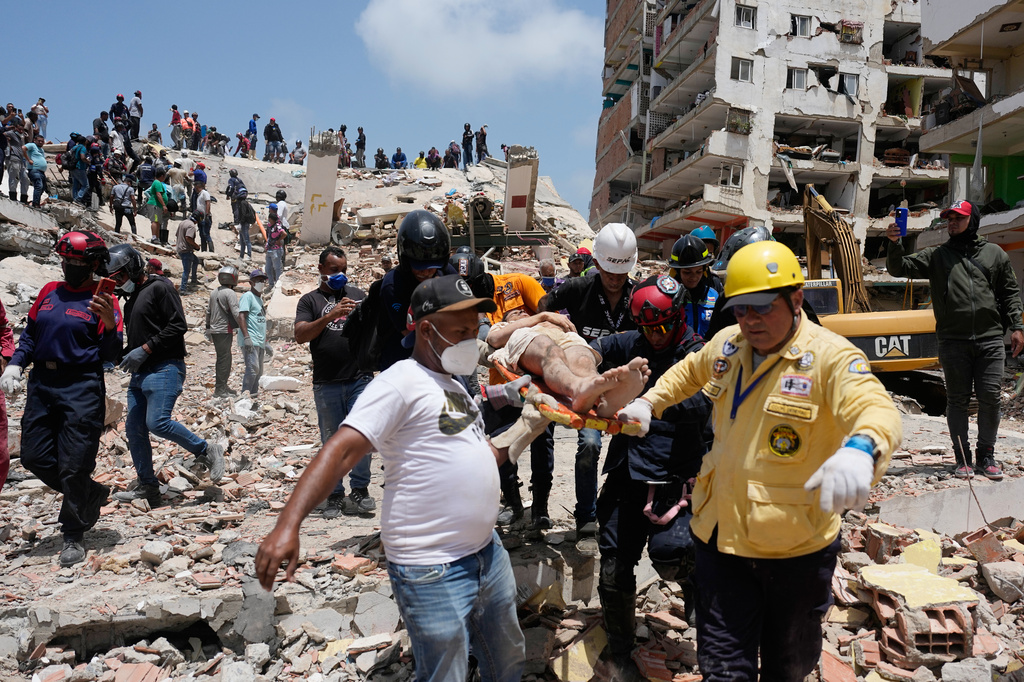 Rescue workers carry Daniel Cordero after pulling him from the rubble two days after an earthquake struck Catia la Mar, Venezuela, Friday, June 26, 2026. (AP Photo/Fernando Vergara)