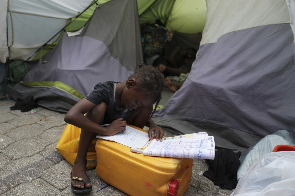 A child does her homework at a church-turned-shelter for people displaced by gang violence in Port-au-Prince, Haiti, Wednesday, Sept. 17, 2025. (AP Photo/Odelyn Joseph)