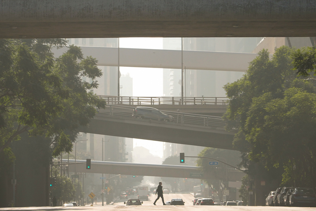 FILE - A person crosses a street as pollution fills the air, Dec. 4, 2024, in Los Angeles. (AP Photo/Andy Bao, File)