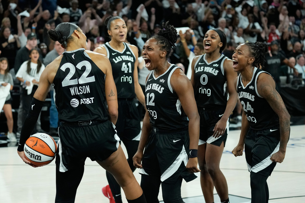 Las Vegas Aces players celebrate after defeating the Indiana Fever in Game 5 of a WNBA basketball playoff semifinals series Tuesday, Sept. 30, 2025, in Las Vegas. (AP Photo/John Locher)