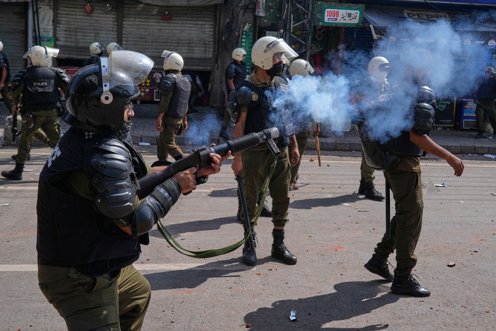 A police person fires tear gas shell to disperse supporters of Islamist party 'Tehreek-e-Labbaik Pakistan' during clashes ahead of their pro-Palestinian march toward capital Islamabad, in Lahore, Pakistan, Friday, Oct. 10, 2025. (AP Photo/K.M. Chaudary)