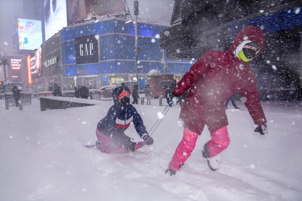 Hannah and Astrid Grimskog play in Times Square during a snow storm, Monday, Feb. 23, 2026, in New York. (AP Photo/Seth Wenig)