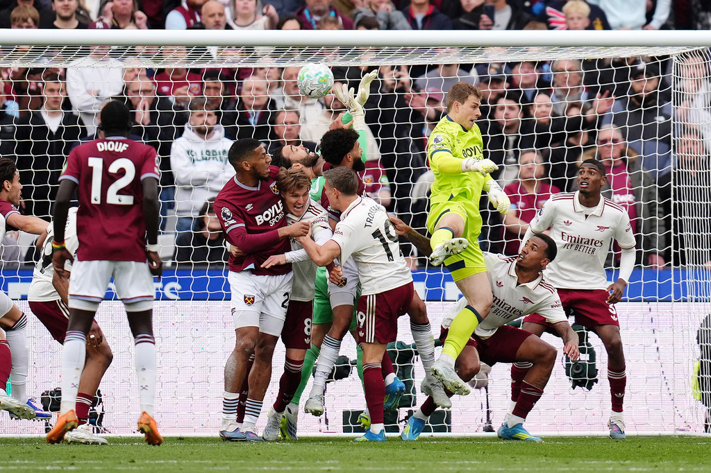 Arsenal goalkeeper David Raya, center, is fouled by West Ham United's Pablo Felipe in the build up to Callum Wilson disallowed goal during the English Premier League match in London, Sunday May 10, 2026. (John Walton/PA via AP)