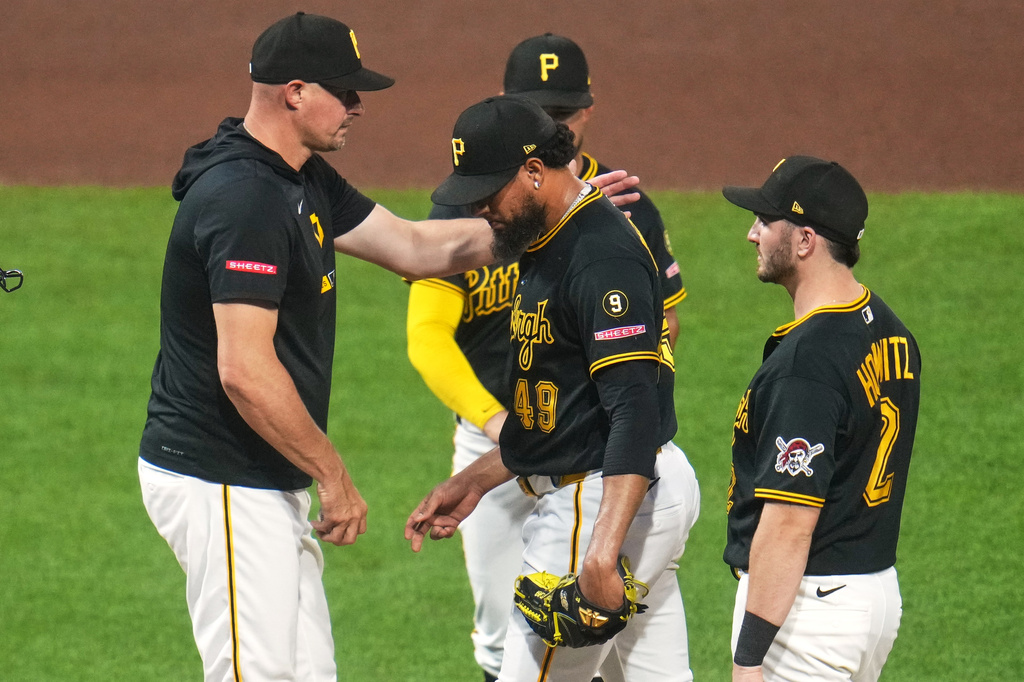 Pittsburgh Pirates pitcher Yohan Ramírez, center, walks off the mound after handing the ball to manager Don Kelly, left, during the seventh inning of a baseball game against the Chicago Cubs in Pittsburgh, Wednesday, May 27, 2026. (AP Photo/Gene J. Puskar)