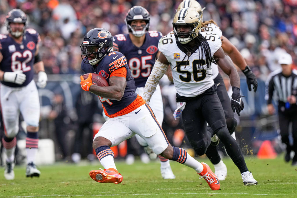 Chicago Bears running back D'Andre Swift (4) carries past New Orleans Saints outside linebacker Demario Davis (56) in the second half of an NFL football game, Sunday, Oct. 19, 2025, in Chicago. (AP Photo/Nam Huh)