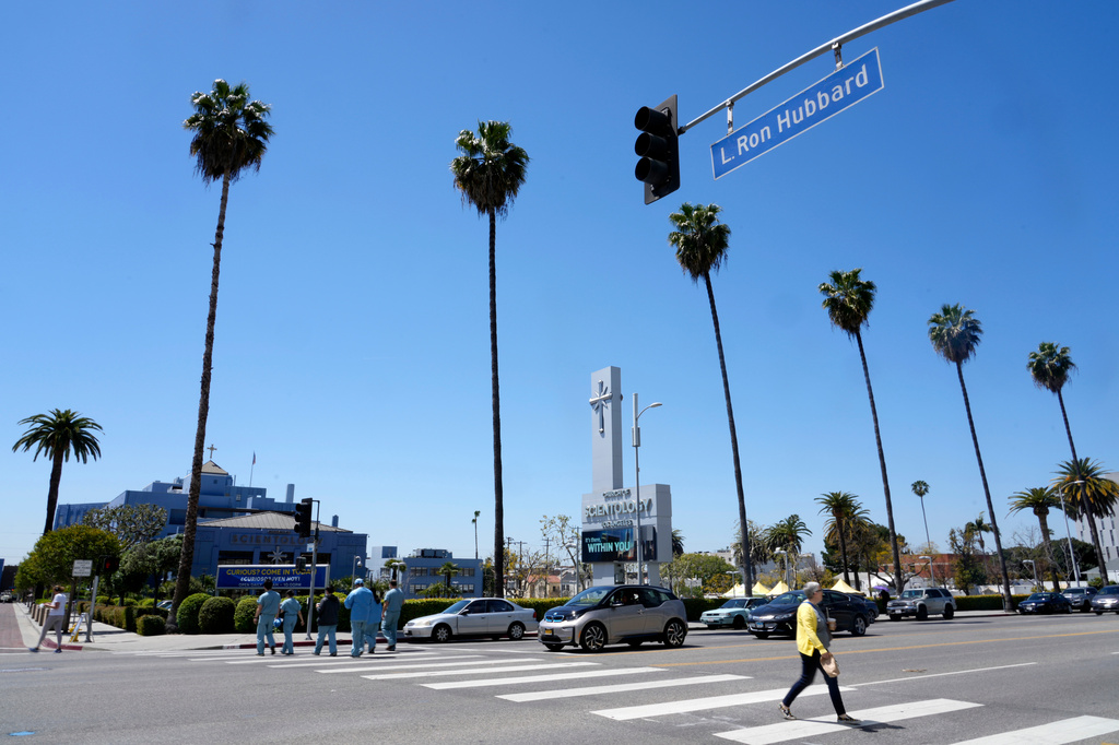 FILE - Pedestrians pass underneath a street sign for L Ron Hubbard Way in front of The Church of Scientology of Los Angeles, April 21, 2023, in Los Angeles. (AP Photo/Chris Pizzello, File)