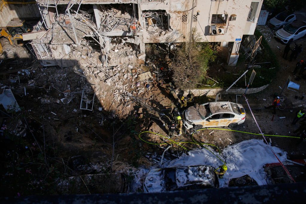 Israeli security forces and rescue team respond at the site of an Iranian missile strike in Tel Aviv, Israel, Tuesday, March 24, 2026. (AP Photo/Ohad Zwigenberg)
