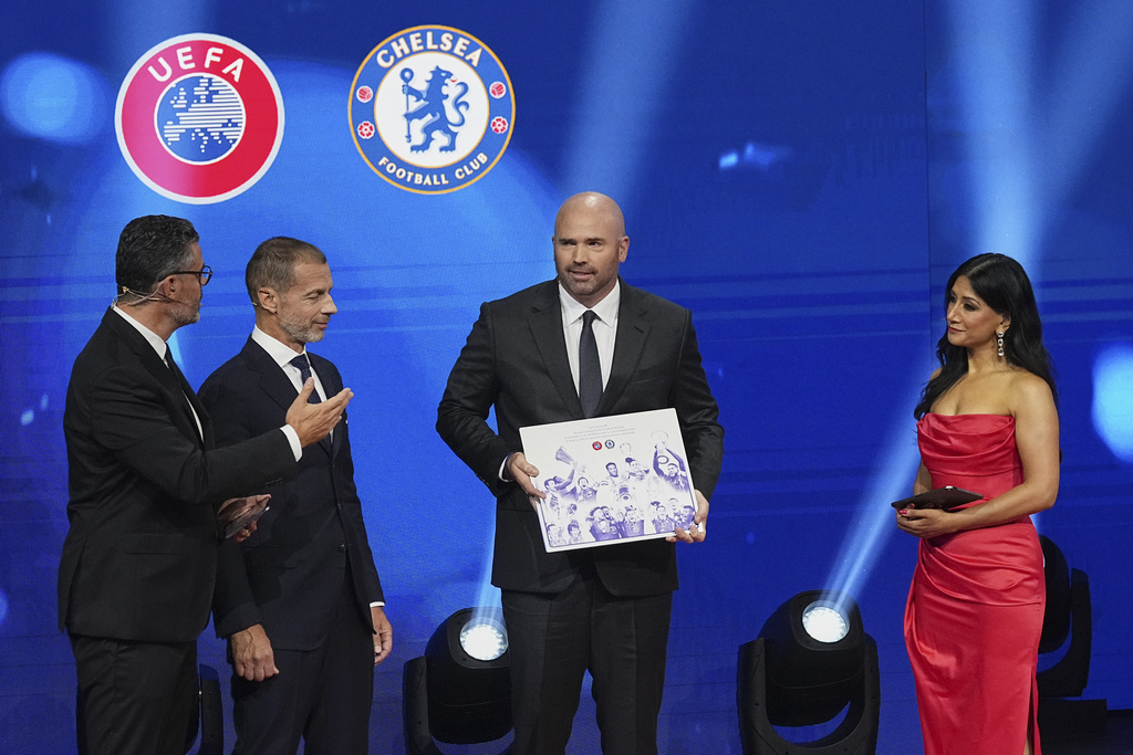 Chelsea's President Jason Gannon, centre, holds the award for winning every UEFA club competition trophy during the Champions League soccer league phase draw in Monaco, Thursday, Aug. 28, 2025. (AP Photo/Laurent Cipriani)