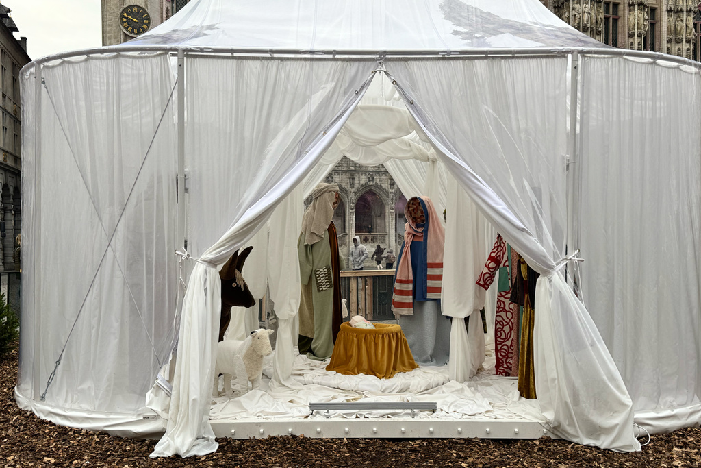 A Nativity scene containing characters with cloth faces, by Belgian artist Victoria-Maria Geyer, is displayed in a white tent in Brussels, Monday, Dec. 1, 2025. (AP Photo/Sylvain Plazy)