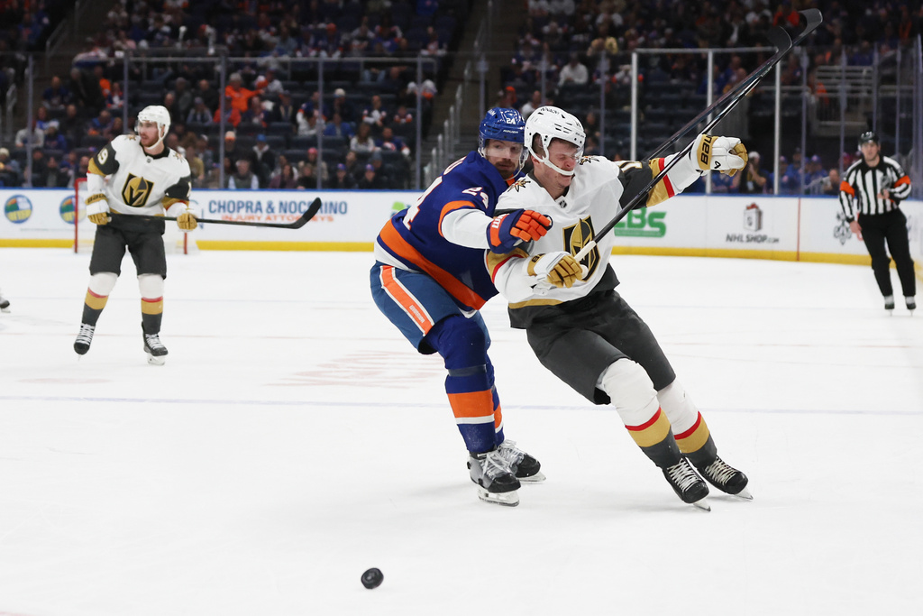 New York Islanders' Scott Mayfield (24) and Vegas Golden Knights' Pavel Dorofeyev collide while going after the puck during the third period of an NHL hockey game, Tuesday, Dec. 9, 2025, in Elmont, N.Y. (AP Photo/Heather Khalifa)