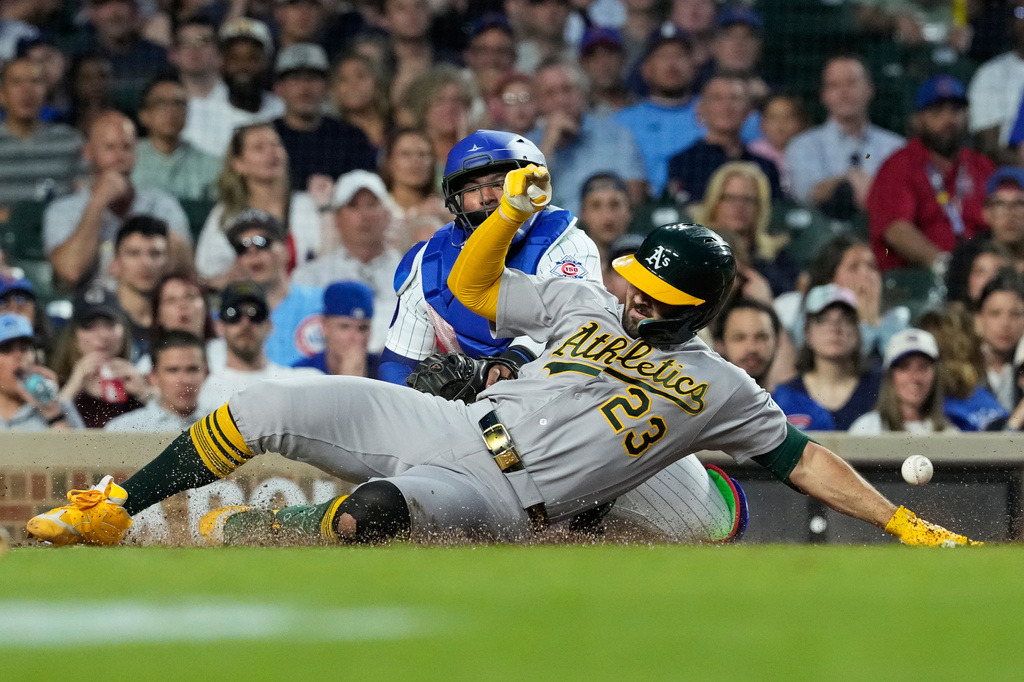 Athletics' Shea Langeliers (23) slides into home after hitting a two-run inside-the-park home run as Chicago Cubs catcher Moisés Ballesteros waits for the ball during the sixth inning of a baseball game against the Chicago Cubs in Chicago, Thursday, June 4, 2026. (AP Photo/Nam Y. Huh)