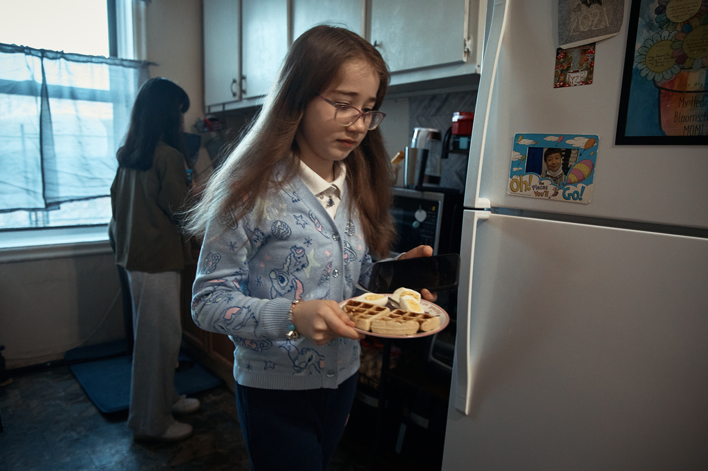 Gulhayo Yuldosheva's daughters have breakfast in an apartment building where tenants report maintenance issues and pest infestations, in the Bronx borough of New York, Tuesday, March 17, 2026. (AP Photo/Andres Kudacki)