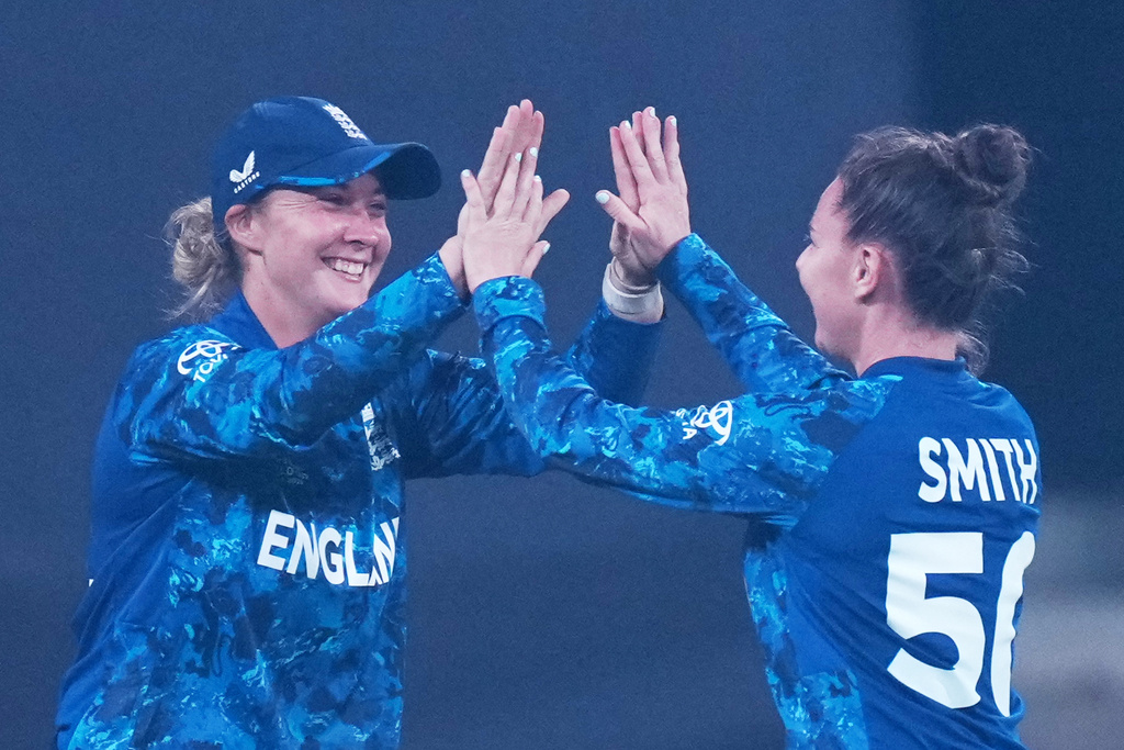 England's Linsey Smith, right, celebrates with teammate the wicket of India's Smriti Mandhana during the ICC Women's Cricket World Cup match between India and England in Indore, India, Sunday, Oct. 19, 2025. (AP Photo/Ajit Solanki)