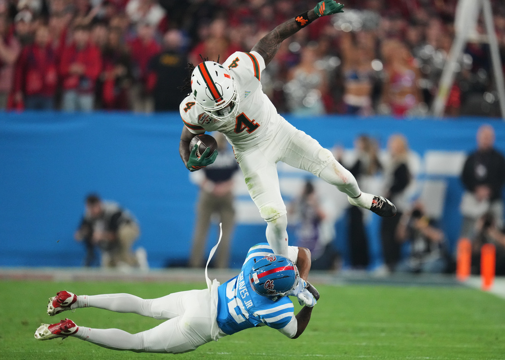 Mississippi cornerback Chris Graves Jr. (32) tackles Miami running back Mark Fletcher Jr. (4) during the first half of the Fiesta Bowl NCAA college football playoff semifinal game, Thursday, Jan. 8, 2026, in Glendale, Ariz. (AP Photo/Ross D. Franklin)