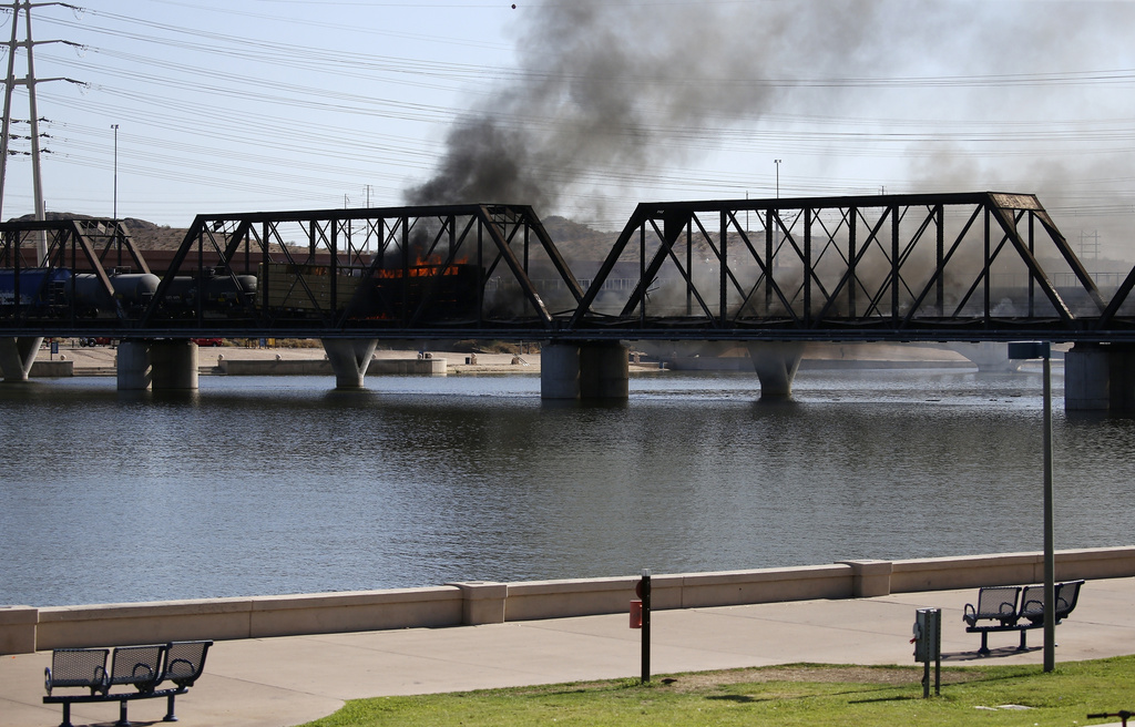 FILE - A derailed freight train burns on a bridge spanning Tempe Town Lake, July 29, 2020, in Tempe, Ariz. (AP Photo/Ross D. Franklin, file)
