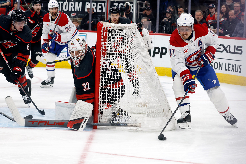 Montréal Canadiens' Brendan Gallagher (11) controls the puck behind Carolina Hurricanes goaltender Brandon Bussi (32) during the third period of an NHL hockey game in Raleigh, N.C., Thursday, Jan. 1, 2026. (AP Photo/Karl DeBlaker)