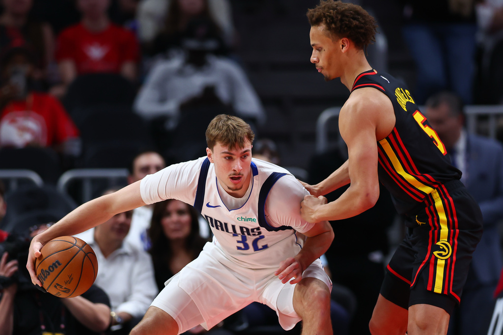 Dallas Mavericks forward Cooper Flagg, left, dribbles against Atlanta Hawks guard Dyson Daniels during the first half of an NBA basketball game, Tuesday, March 10, 2026, in Atlanta. (AP Photo/Colin Hubbard)