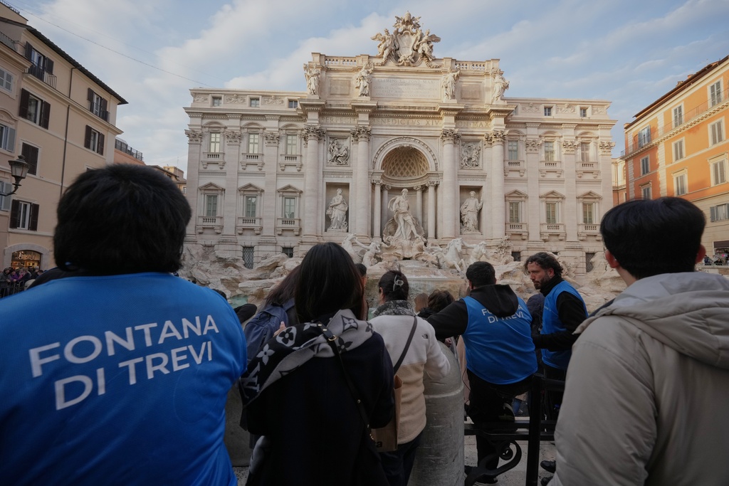 Staff controls the flow of visitors at Rome's Trevi Fountain, Friday, Dec. 19, 2025, as the city municipality announced that, starting on Feb. 1, it will impose a 2 euro fee for tourists to get close to the fountain. (AP Photo/Andrew Medichini)