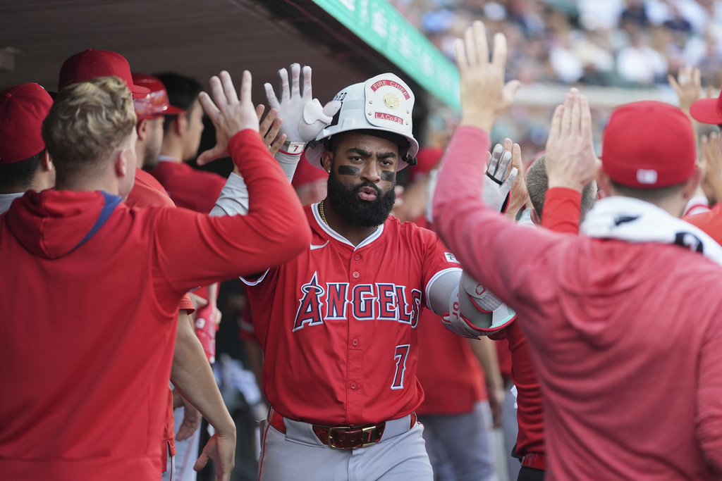 Los Angeles Angels' Jo Adell celebrates in the dugout after hitting a go-ahead three-run home run during the fourth inning of a baseball game against the Detroit Tigers, Saturday, Aug. 9, 2025, in Detroit. (AP Photo/Ryan Sun)