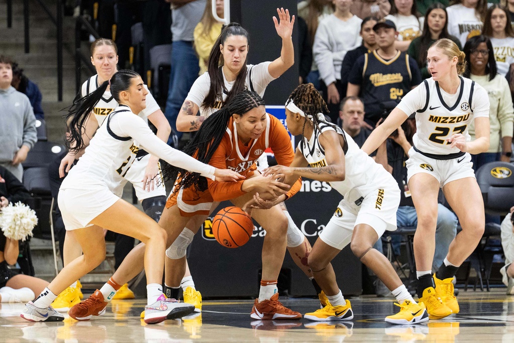 Texas' Breya Cunningham, center, has the ball knocked away as she is surrounded by Missouri players during the first half of an NCAA women's basketball game Thursday, Jan. 1, 2026, in Columbia, Mo. (AP Photo/L.G. Patterson)