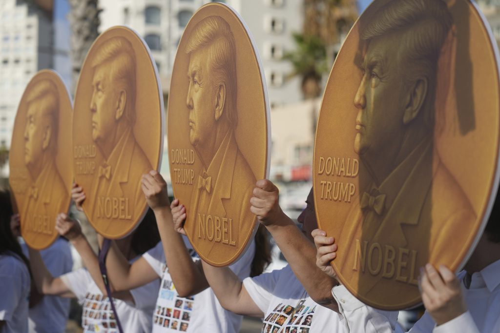Demonstrators wear shits with photos depicting the faces of Israeli hostages who are being held in the Gaza Strip, during a protest demanding their release, outside the U.S. Embassy Branch Office in Tel Aviv on Tuesday, Sept. 2, 2025. (AP Photo/Ariel Schalit)